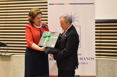 Marta Rosende, Gerente de Cuentas ACHS para la Universidad de Chile, haciendo entrega del premio de reconocimiento al Jefe Administrativo IDIEM, Jorge Flores