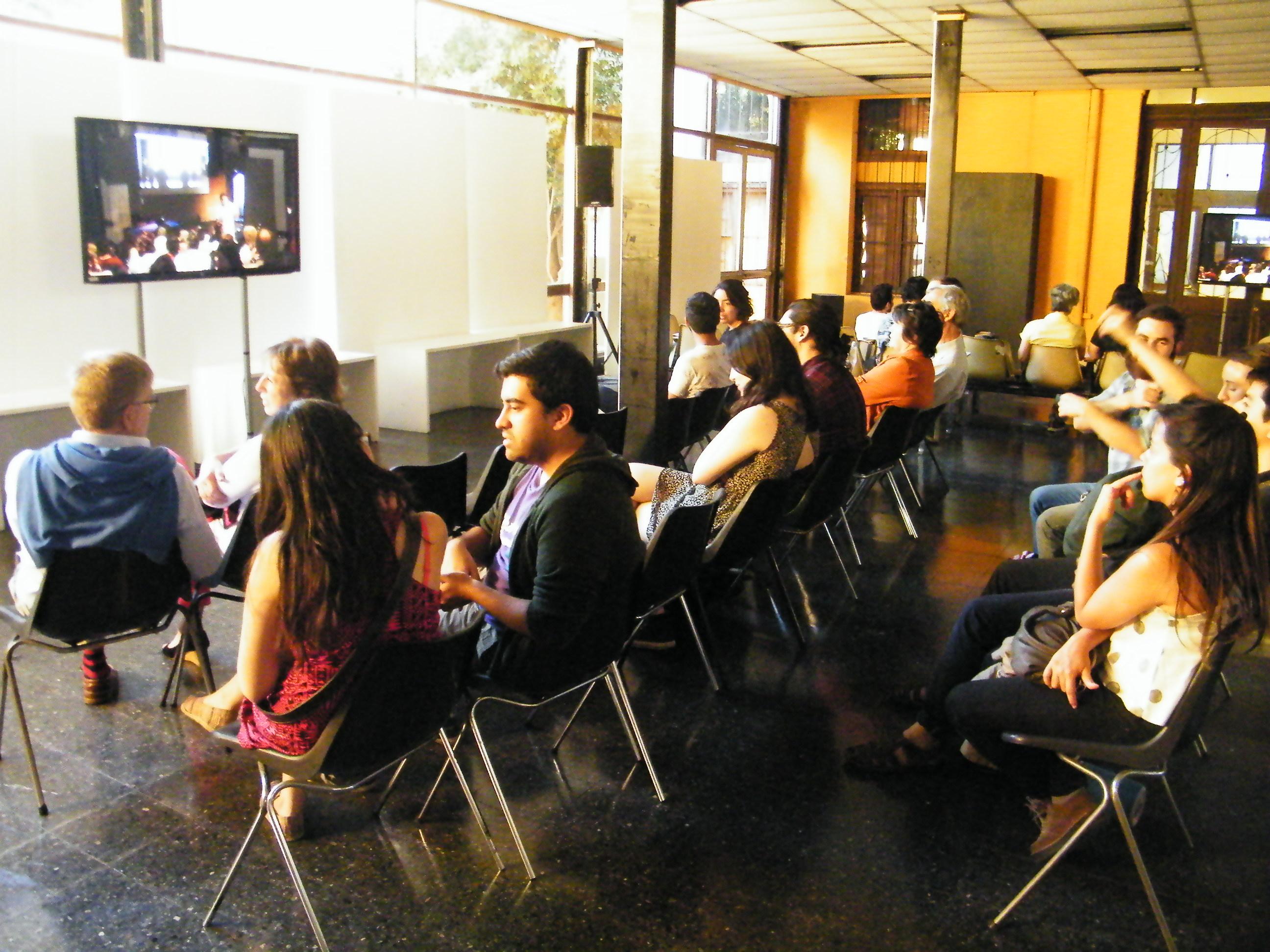 Público siguiendo la presentación desde el Hall Central de la FAU