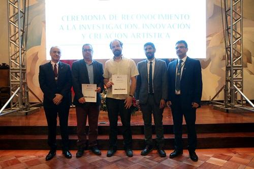Maximiano Atria y Mauricio Vico (en representación de Leonardo Soto), recibiendo sus reconocimientos a la creación artística de manos del Vicerrector Salazar, el Director Gaspar y el Decano Amaya 
