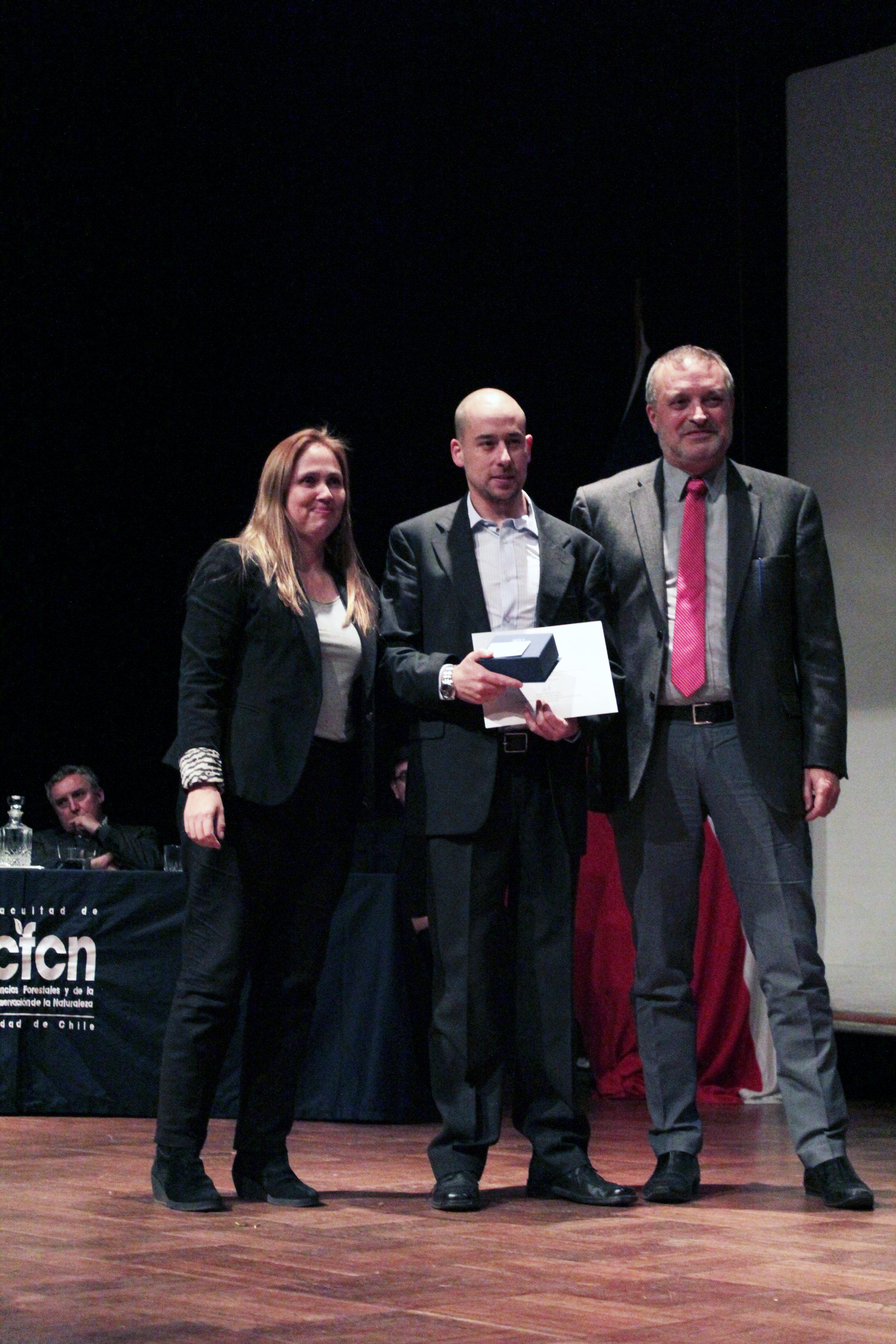 Alexis Segovia junto a Claudia Cerda, su profesora guía en la tesis premiada y Juan Caldentey, vicedecano de la FCFCN, en la ceremonia de graduación. 