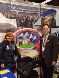 Stand de Chile con logo del Congreso IAPD Chile 2017. Dra Alejandra Lípari, docente U. de Chile junto a Dr.  Anthony  Tsong, Presidente de IAPD.