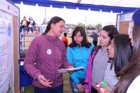 Directora del proyecto, Dra. Soledad Burgos, junto a un grupo de alumnos exponiendo su poster.