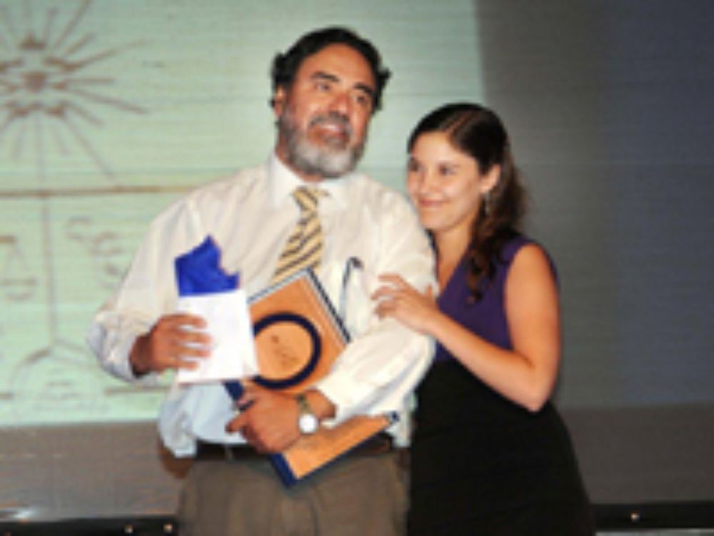El doctor Hugo Sanhueza, de Campus Norte, recibe el premio como mejor docente de manos de la doctora Lara Fernández.