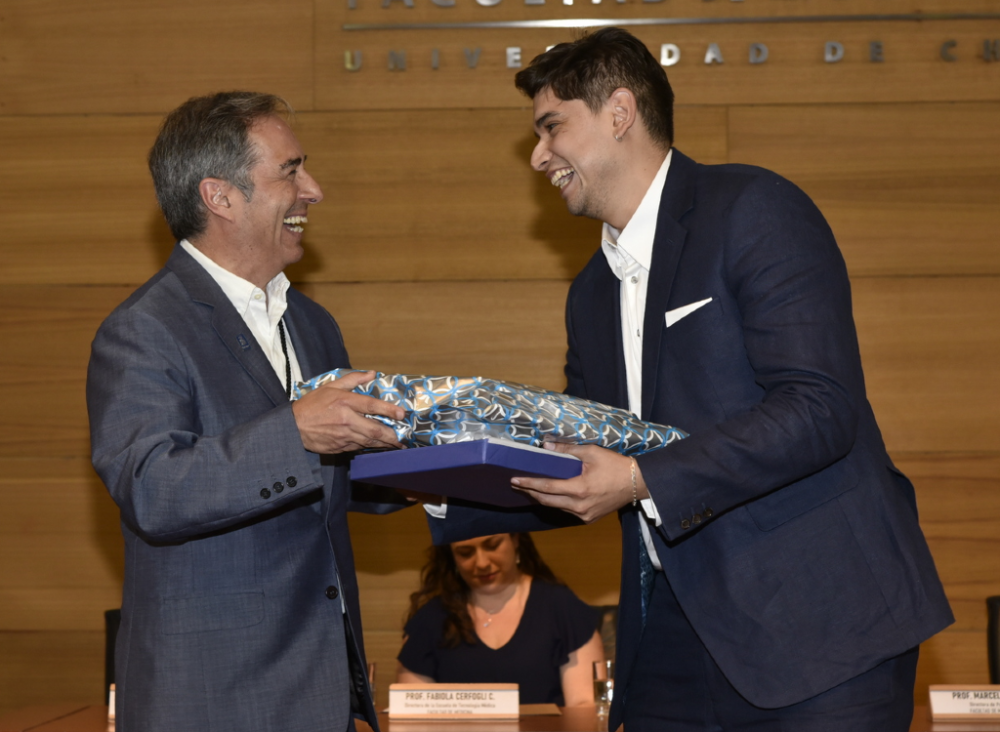 El doctor Miguel O’Ryan premió al tecnólogo médico Joaquín Torres como el mejor rendimiento académico de su generación.