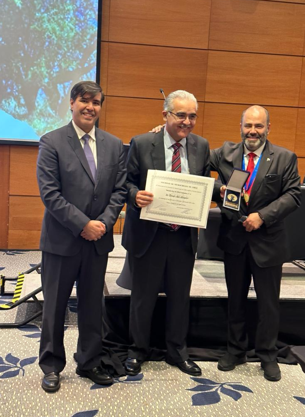 El doctor Rómulo Melo recibió la distinción de manos de los doctores David Rojas -quien hizo la semblanza de su trayectoria académica- y del doctor Jorge Mura; todos, del Departamento de Ciencias Neurológicas Oriente de la Facultad de Medicina. 