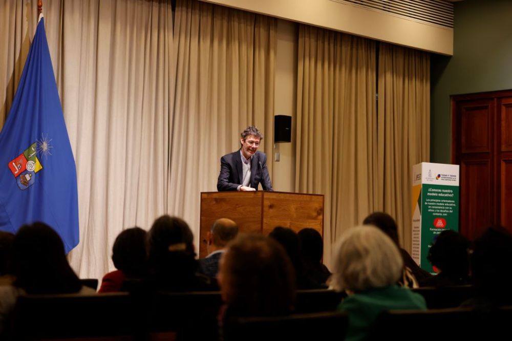 Vicerrector Pastenes hablando en la testera de la sala Ignacio Domeyko, al frente se ve parte del público.