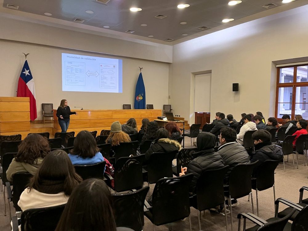 Sala Eloísa Díaz, desde atrás, se ve con sus asientos ocupados de jóvenes escuchando una charla sobre el Ingreso Prioritario de Equidad Educativa (SIPEE)