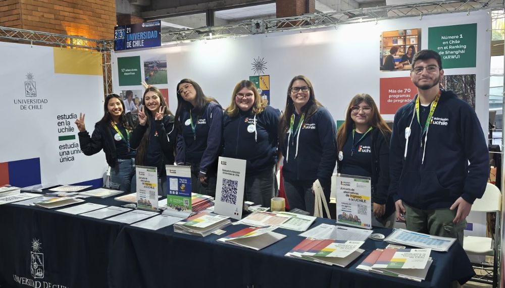 Monitoras y monitor posando ante la cámara en stand de la Universidad de Chile en Protagonistas 2030