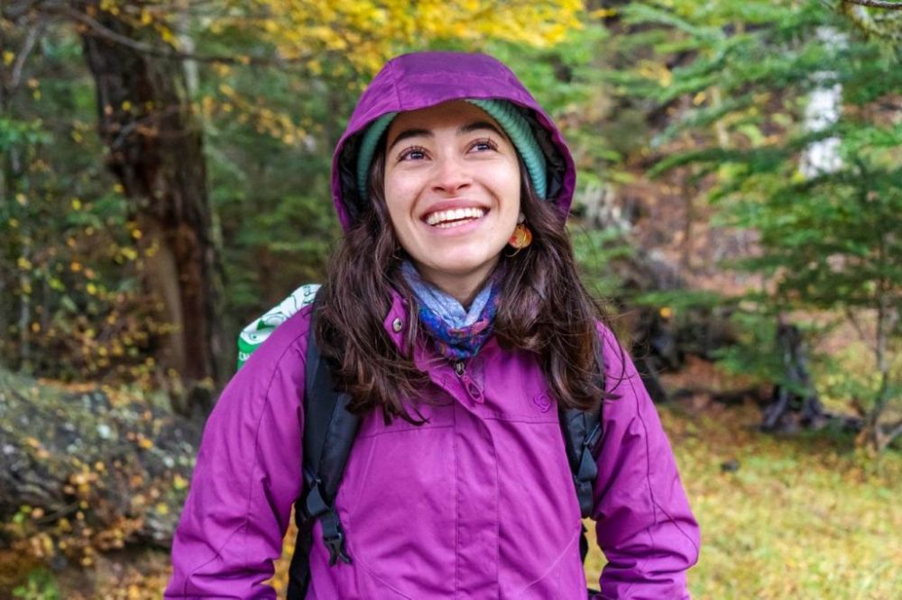 Plano medio corto de Francisca Coloma sonriendo y de fondo un bosque. 