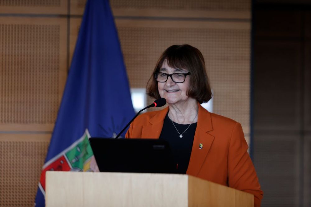 Rectora Rosa Devés sonriendo mientras da la bienvenida en la testera