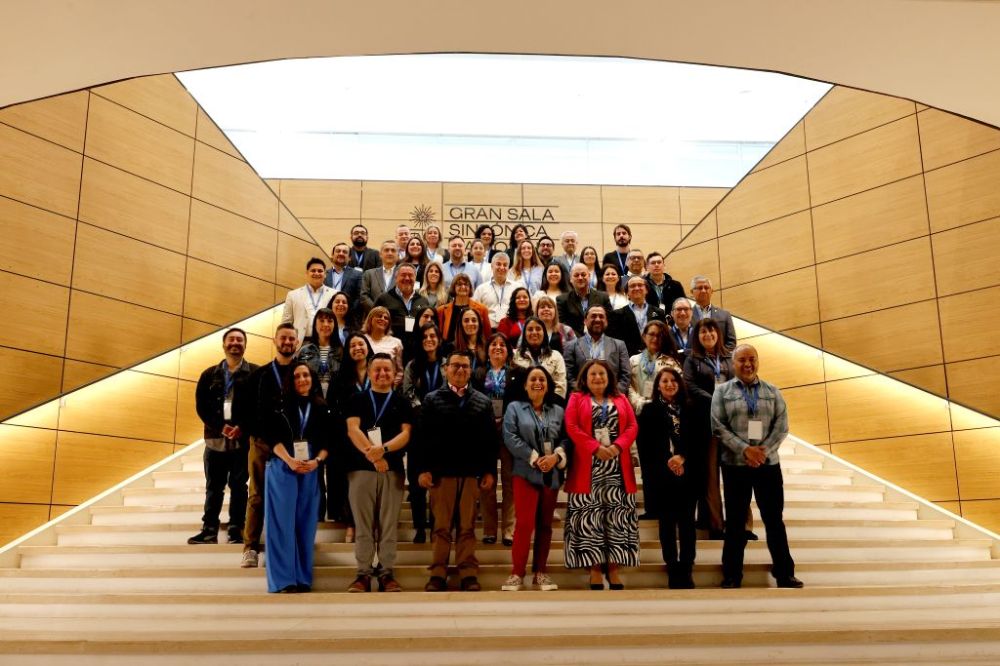 Fotografía oficial grupal de todas las personas participantes de la jornada plenaria, en la escalera que da a la sala sinfónica de VM20