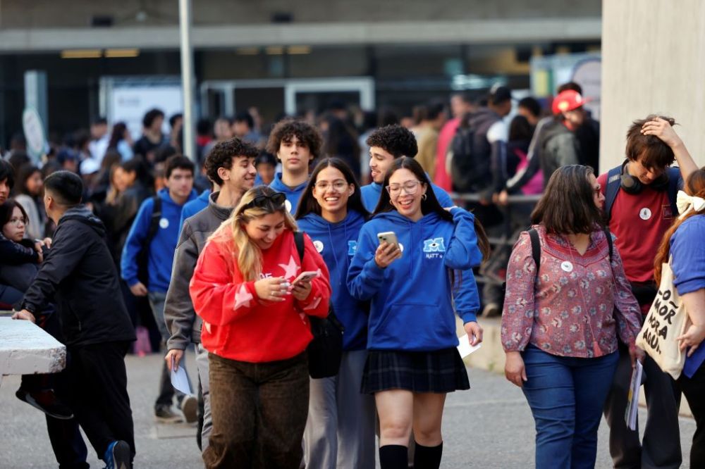 Escolares sonrientes, con uniforme, caminan en el exterior de la Plataforma Cultural JGM