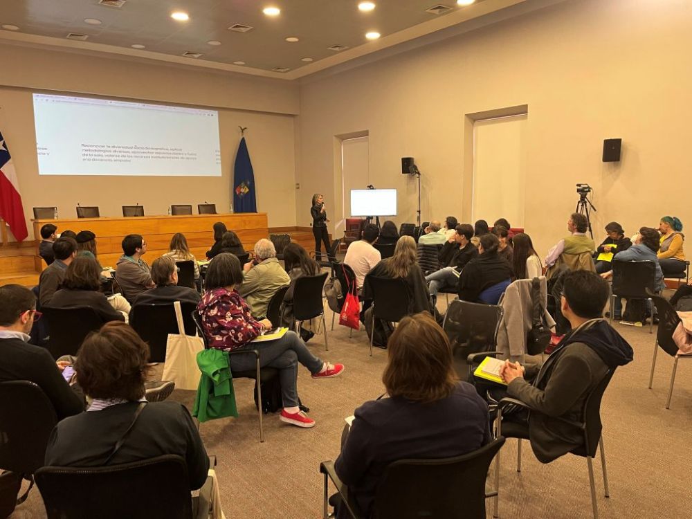 Docentes sentados en grupos, en sala Eloísa Díaz, miran hacia adelante a Viviana Sobrero que está hablando