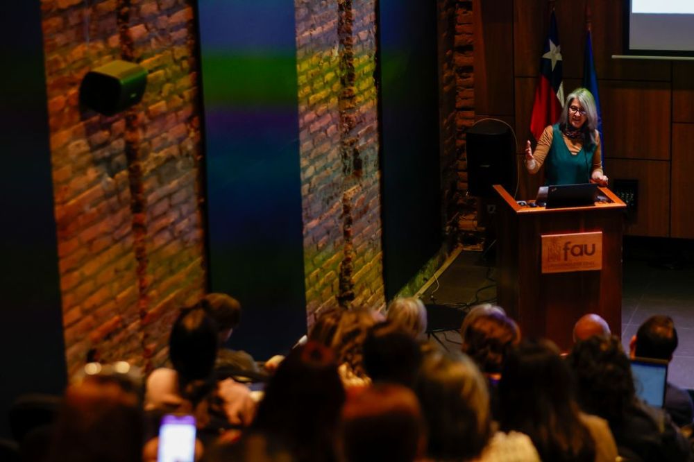 Viviana Sobrero en la testera del auditorio FAU. Se ve también parte del público