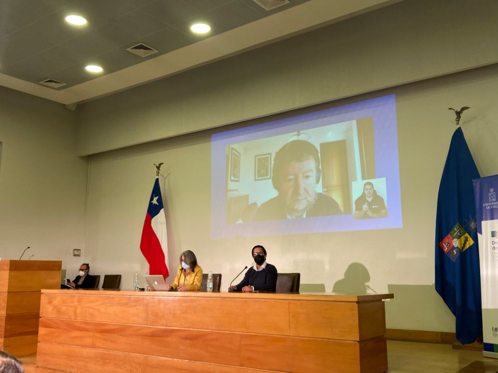 Testera en la que están Viviana Sobrero y Julio Labraña. Atrás, proyectado el vicerrector Piquer en una videollamada