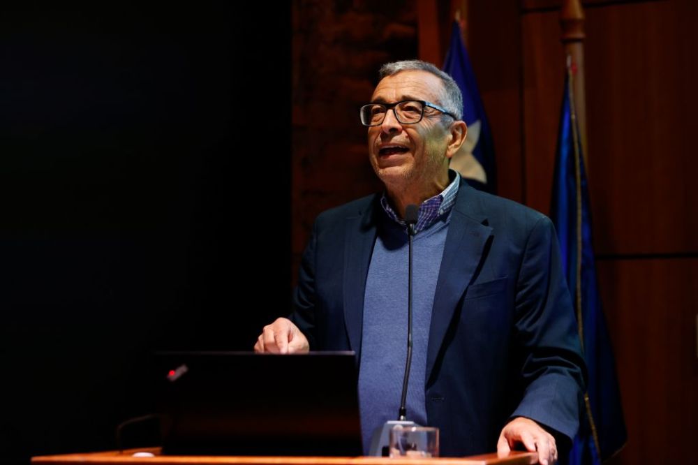 Plano medio de Andeljalil Akkari, hablando en la testera del auditorio de la Facultad de Arquitectura y Urbanismo de la Universidad de Chile