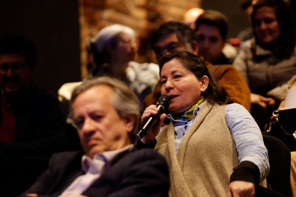 Profesora asistente haciendo una pregunta con micrófono