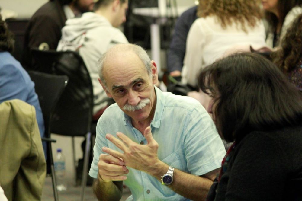 Primer plano de profesor conversando en el círculo de un taller con otra profesora.