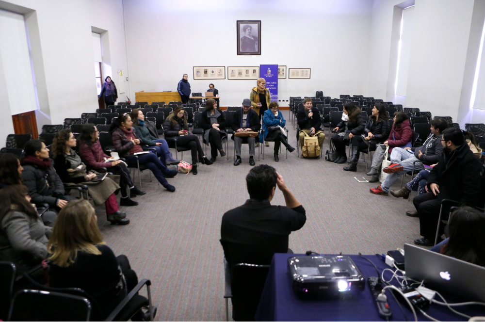Docentes dialogando en círculo en una sala
