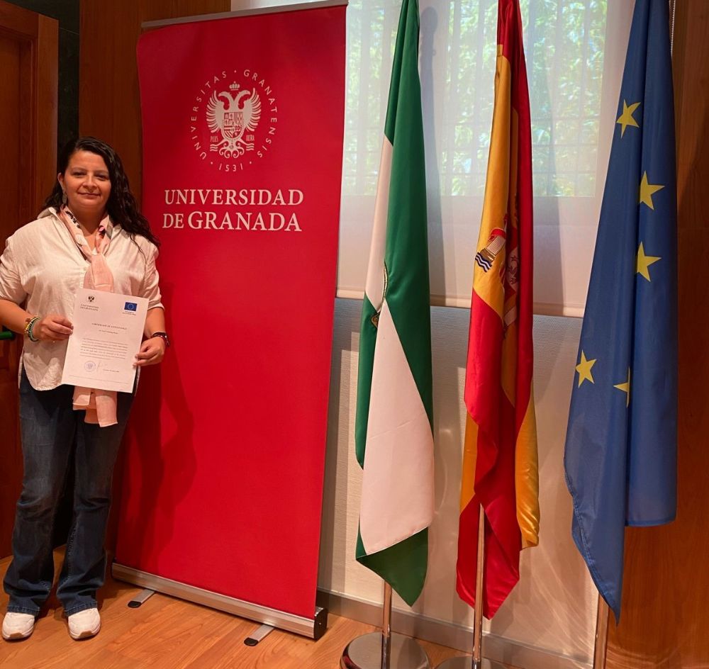 Valeska Castillo con el certificado del programa Erasmus en la Universidad de Granada, al finalizar el periodo de intercambio profesional en la universidad española.