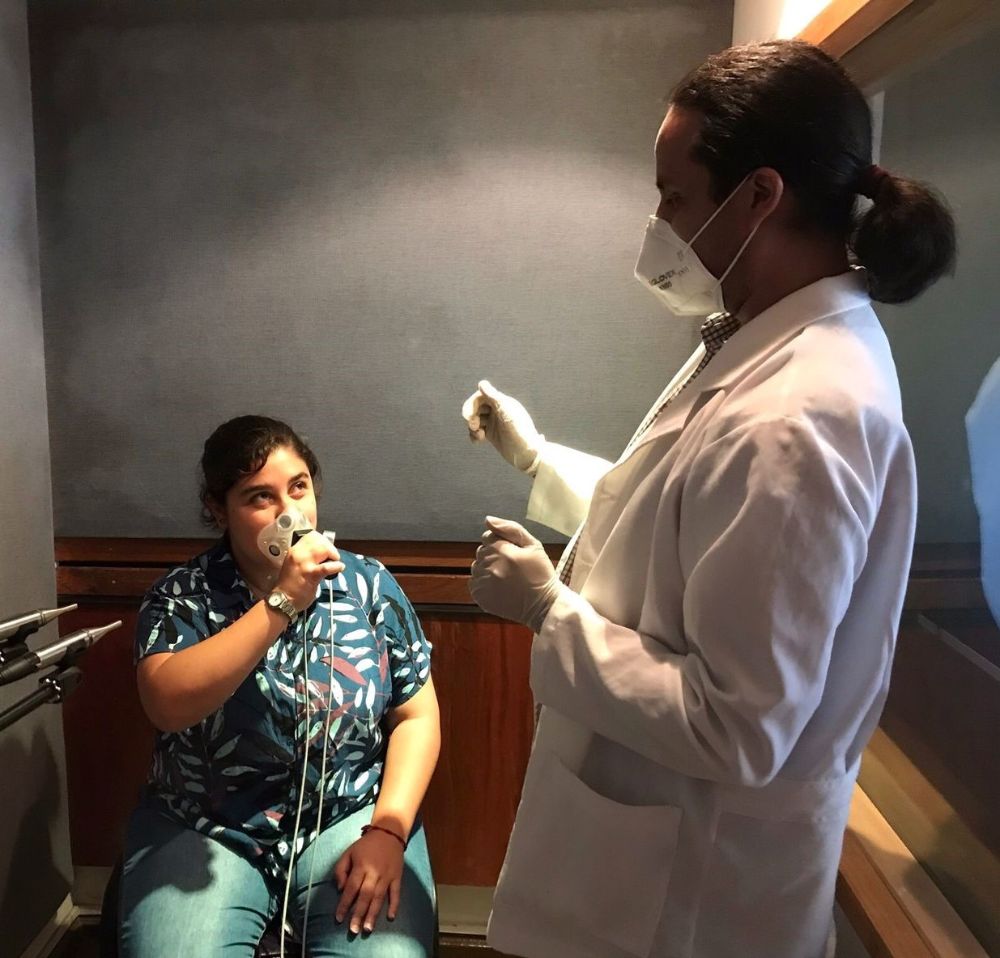 “La instalación de este laboratorio es un hito, dada la multiplicidad de intereses y tópicos abordados en el DSON", explica el profesor Víctor Espinoza. En la fotografía: El fonoaudiólogo y profesor Christian Castro entrega instrucciones a participante del estudio, en la sala de grabaciones del "VoiceLab-DSON".