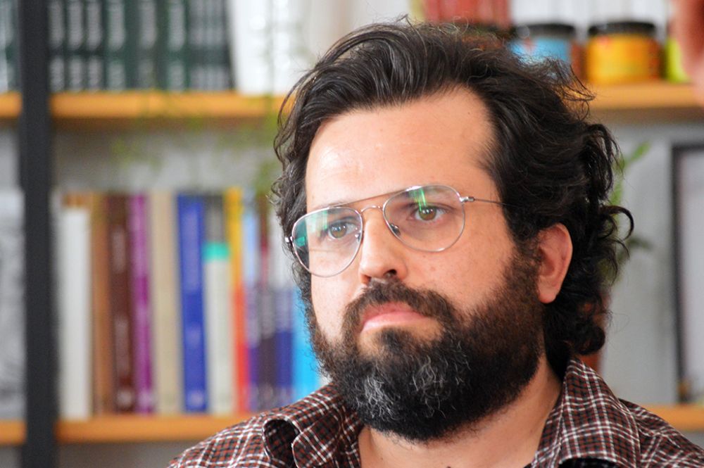 psicoanalista Danilo Sanhueza, detrás de un librero repleto de textos psicologicos 