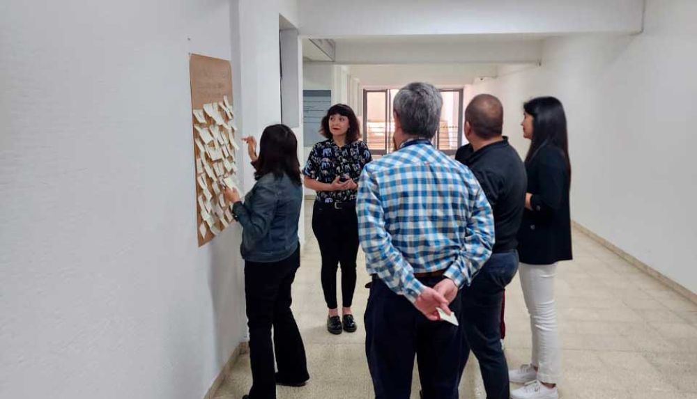 Grupo de personas anotando ideas centrales en papelógrafo.