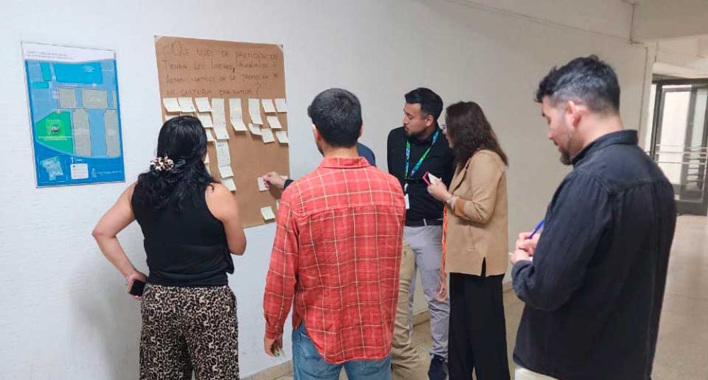 Grupo de personas anotando ideas centrales en papelógrafo.