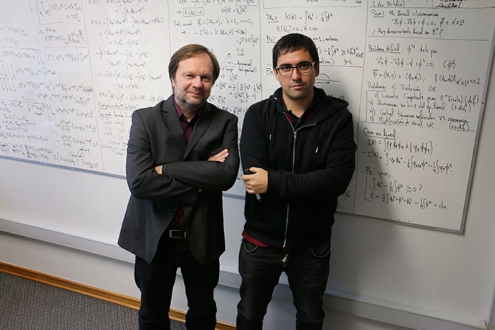 Micha&#322; Kowalczyk y Claudio Muñoz junto a parte de los cálculos usados para descifrar este misterio de más de cuatro décadas de existencia.