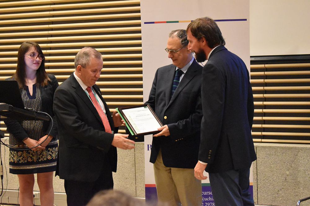 Jorge Flores, Jefe Administrativo IDIEM, recibiendo el reconocimiento por parte del Director IDIEM, Fernando Yáñez, junto a José Esteban Garay, Gerente de Instituciones y Grandes Clientes ACHS 