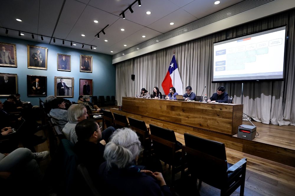 Podio en la Sala Domeyko con los panelistas del foro.