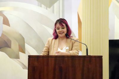 Fernanda Uribe, jefa de la Unidad de Aprendizaje del Departamento de Pregrado, hablando en la testera del Salón de Honor de la Casa Central de la U. de Chile.