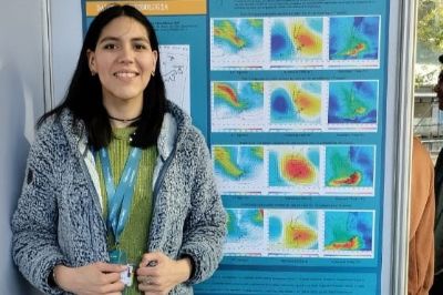 La tesista del Magíster en Meteorología y Climatología (MMC), Victoria Moya, junto a su póster de investigación sobre eventos extremos en la Antártica presentado en el II Simposio de Postgrado.