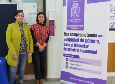 La profesora Denisse Quijada, directora de Igualdad de Género, junto a Carolina Carstens, coordinadora de Institucionalización de Igualdad de Género, mostrando los nuevos dispensadores de preservativos instalados en el hall de la cafetería.