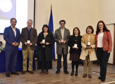 El doctor Miguel O'Ryan y la doctora Ulrike Kemmerling, directora académica, junto a los profesores asociados homenajeados: Renzo Tassara, Lilianette Nagel, Rubén Mercado, María Teresa López y Electra González. 