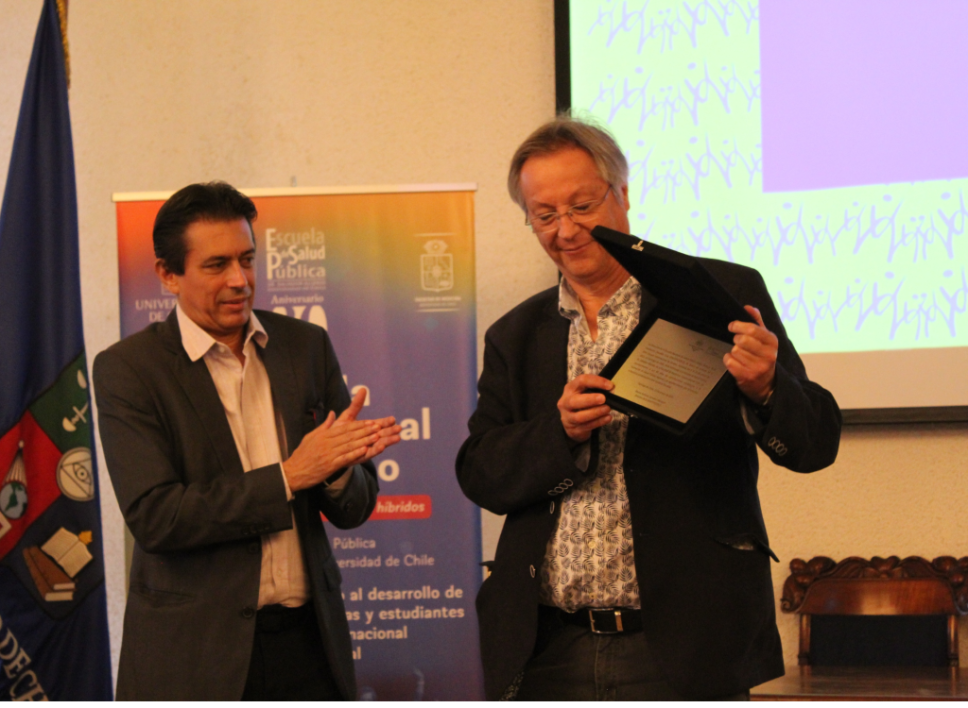 El profesor Marco Menezes hizo entrega de un reconocimiento al doctor Óscar Arteaga, como parte de un homenaje a la labor de la Escuela de Salud Pública a los 80 años de su creación.