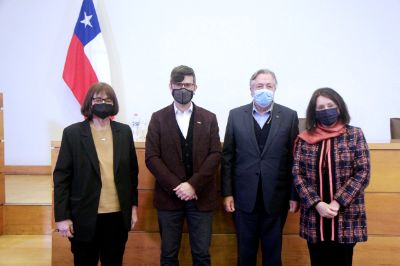 Autoridades posan a la cámara delante de la testera, con mascarilla. Atrás, una bandera chilena