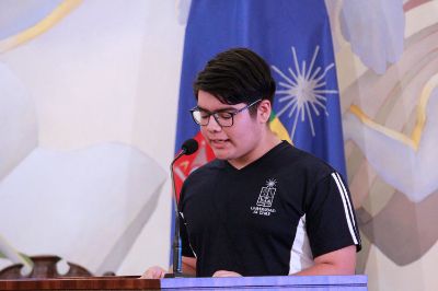 Plano medio de Jessiel León, estudiante de segundo año, hablando en la testera del Salón de Honor de Casa Central de la Universidad de Chile.