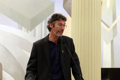 Plano medio de Claudio Pastenes, vicerrector de Asuntos Académicos, hablando en la testera del Salón de Honor de Casa Central de la U. de Chile.