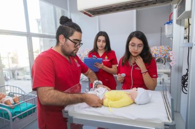 Estudiantes de Obstetricia en simulación clínica con un recién nacido