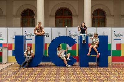 Letras gigantes UCH, con estudiantes posando en ellas, al interior de Casa Central