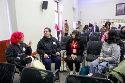 Estudiantes conversando en círculo en la sala Eloísa Díaz, de Casa Central