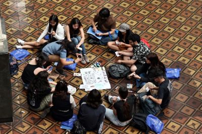 Vista desde arriba de estudiantes en círculo, sentados en el piso del patio Andrés Bello, trabajando en grupo