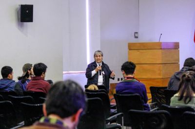 Profesora Ximena Zúñiga hablando al público en la sala