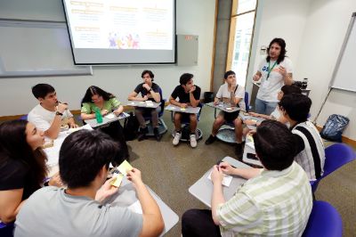 La imagen muestra a las/os asistentes reunidos trabajando en las mesas de trabajo. 