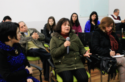 Asistente a la charla realizando una pregunta y dialogando con Marco Avilés.