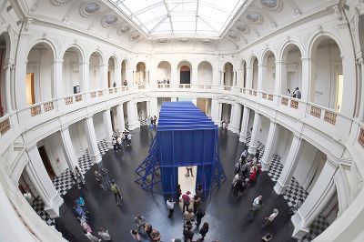 Esta muestra expone la experiencia comunitaria de la población José María Caro, a través de pinturas que se encuentran contenidas dentro de un gran volumen de madera de pino azul.